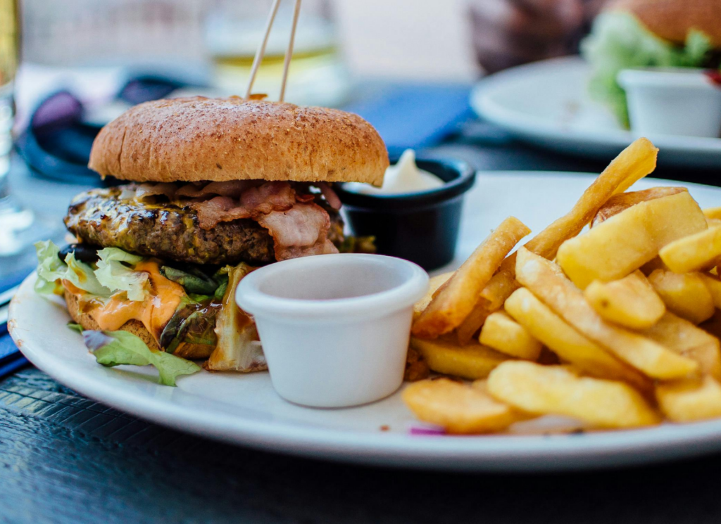 Picture of a pub lunch, a stuffed beef burger with chips and dips