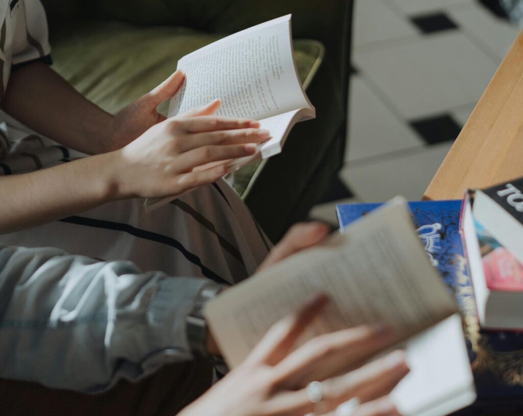 An image of two people sat reading books