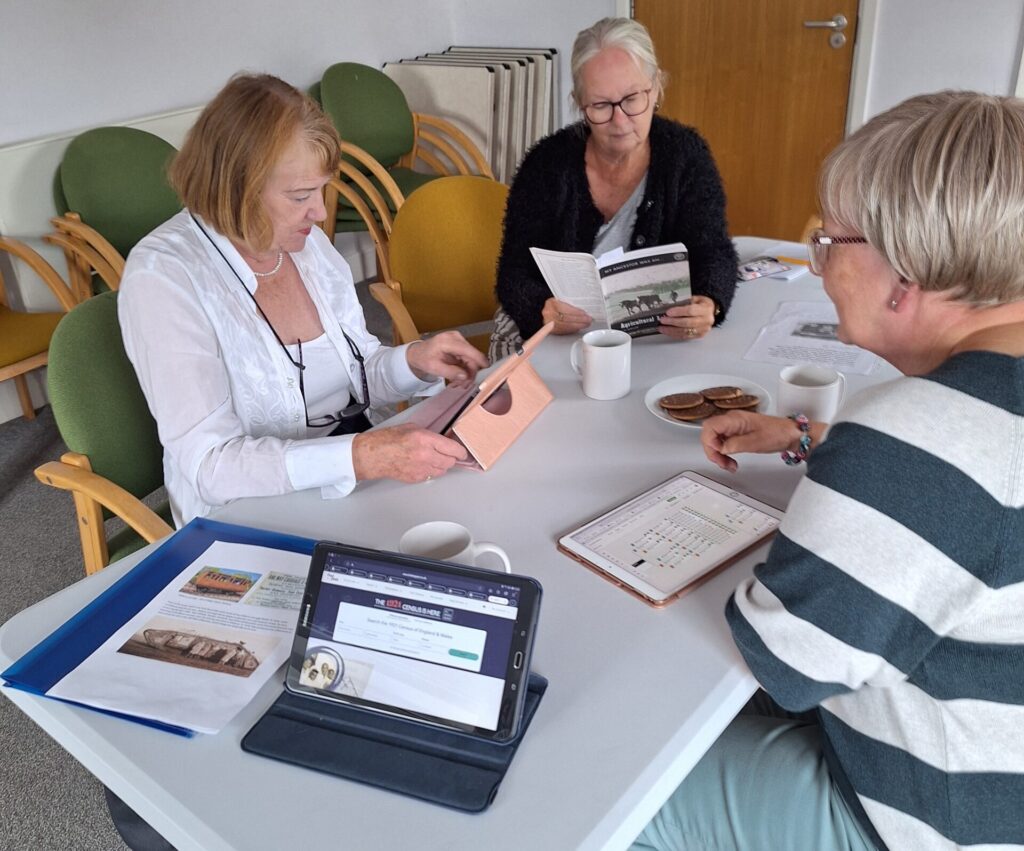 A group of 3 people sat around a table researching